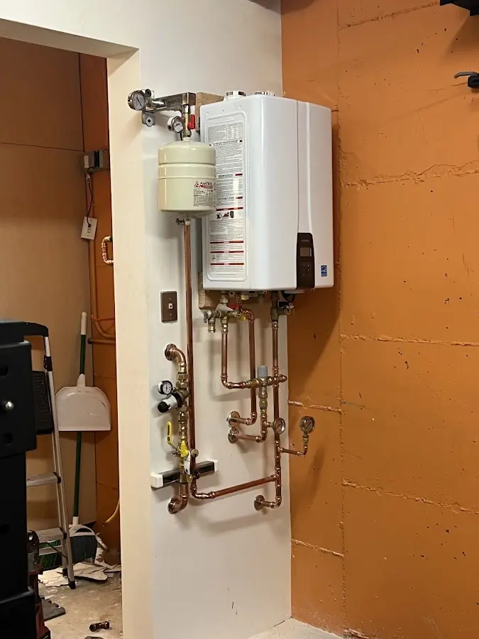 Plumbing technician inspecting water heater connections in Winter Gardens